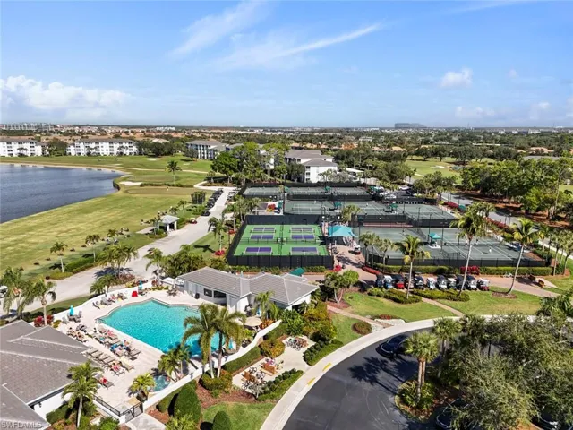 Aerial view of the Club House Pool with pickle ball and tennis courts in the back ground, and drive up golf cart parking