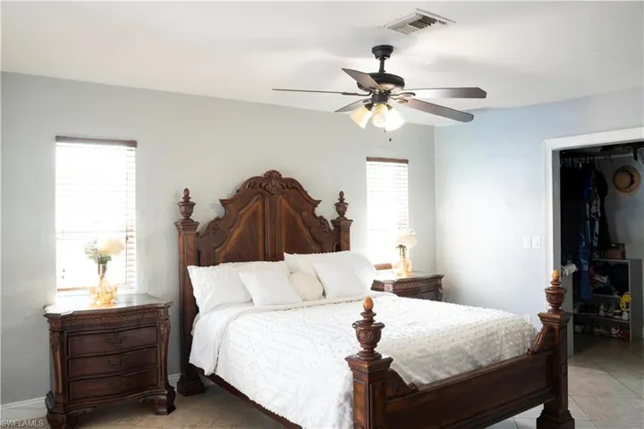 Bedroom with ceiling fan and light tile patterned flooring