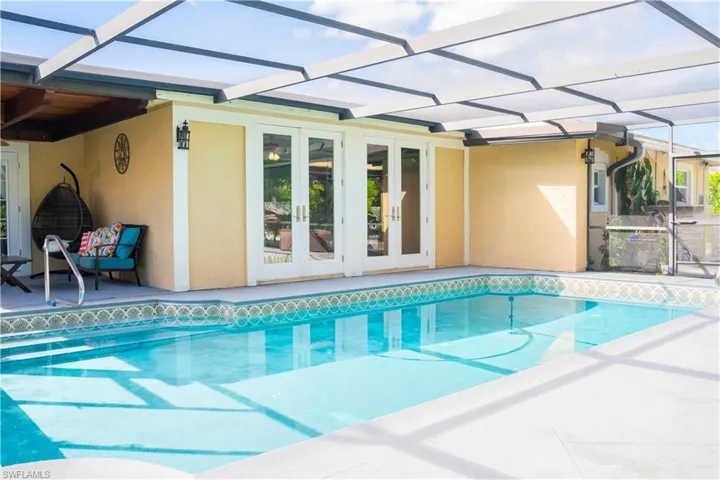 Outdoor pool featuring glass enclosure, a patio, french doors, and a sunroom