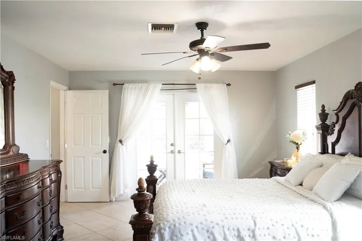 Bedroom featuring light tile patterned floors, a ceiling fan, and access to outside