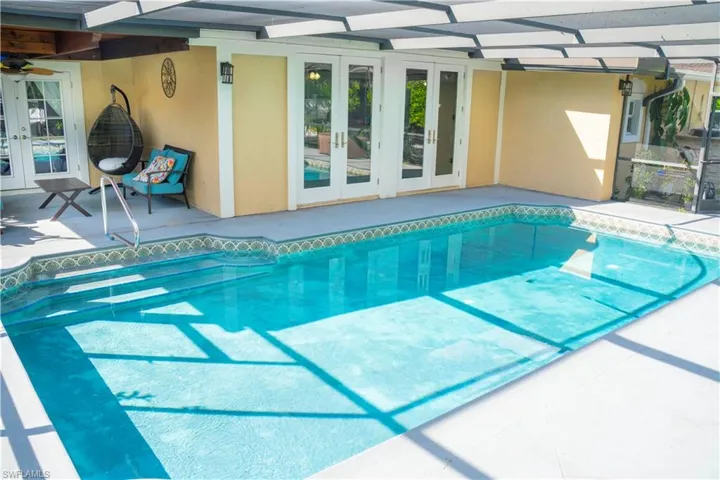 Outdoor pool with french doors, a patio, and a lanai