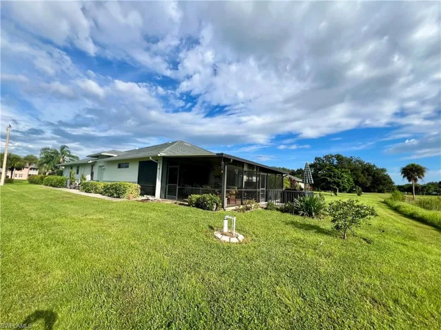 Rear view of property with a yard and a sunroom