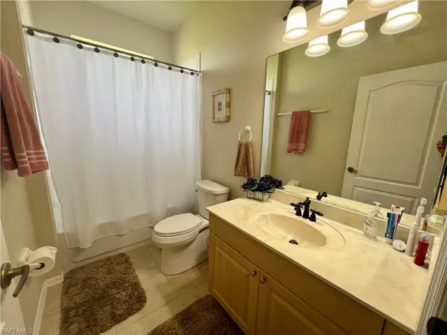 Full bathroom featuring vanity, shower / tub combo, toilet, and tile patterned floors