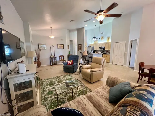 Tiled living room with a towering ceiling and ceiling fan