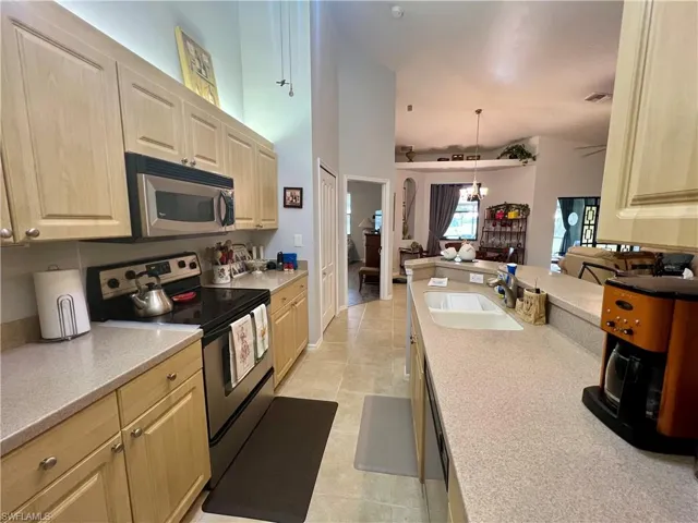 Kitchen, appliances with stainless steel finishes, decorative light fixtures, and sink