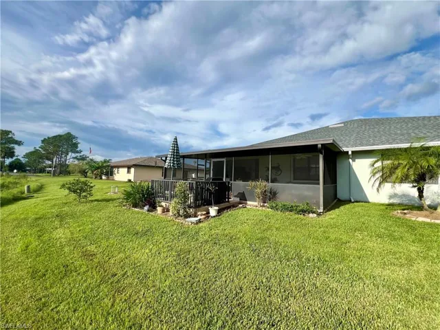 Back of property featuring a lawn and a sunroom