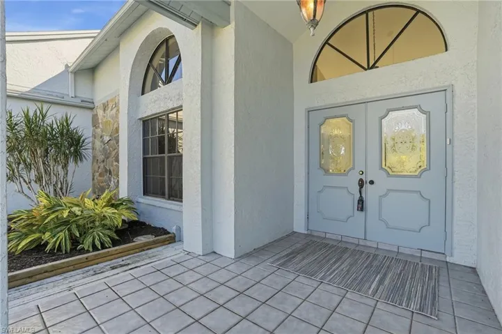 Doorway to property featuring french doors, a patio, and stucco siding