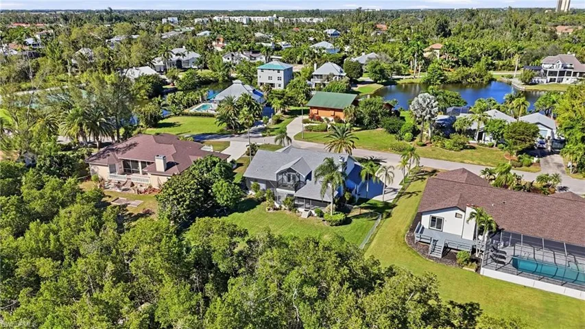 Aerial perspective of suburban area with a nearby body of water and a pool area