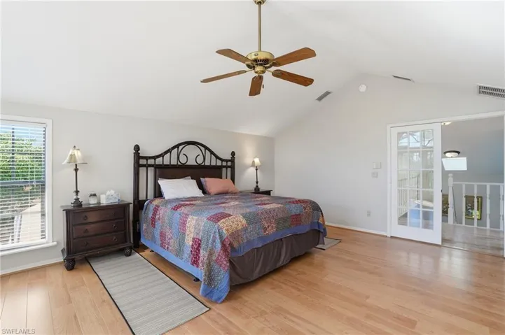 Bedroom featuring light wood finished floors, ceiling fan, and high vaulted ceiling