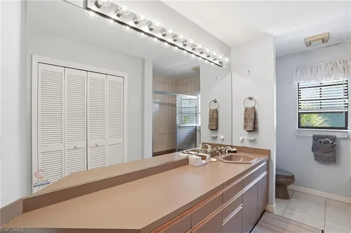 Bathroom with light tile patterned floors, healthy amount of natural light, a stall shower, and vanity