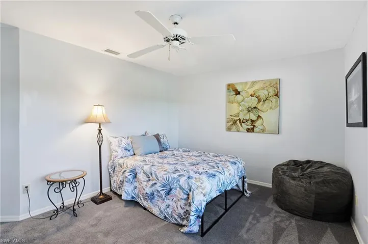 Bedroom featuring a ceiling fan and carpet