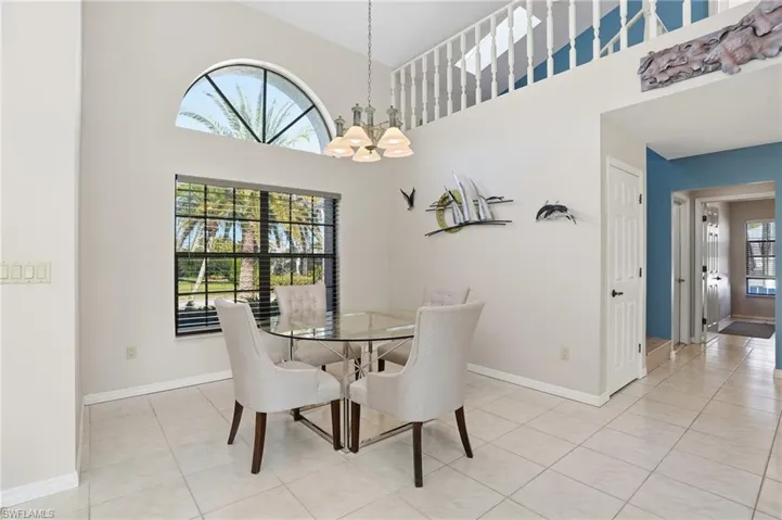 Dining room featuring light tile patterned flooring, a high ceiling, and a chandelier