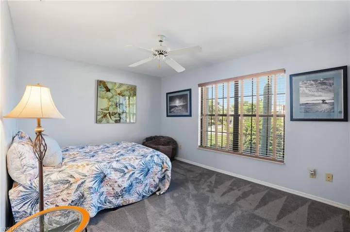 Carpeted bedroom featuring a ceiling fan and baseboards