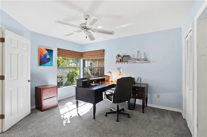 Office with carpet and a ceiling fan