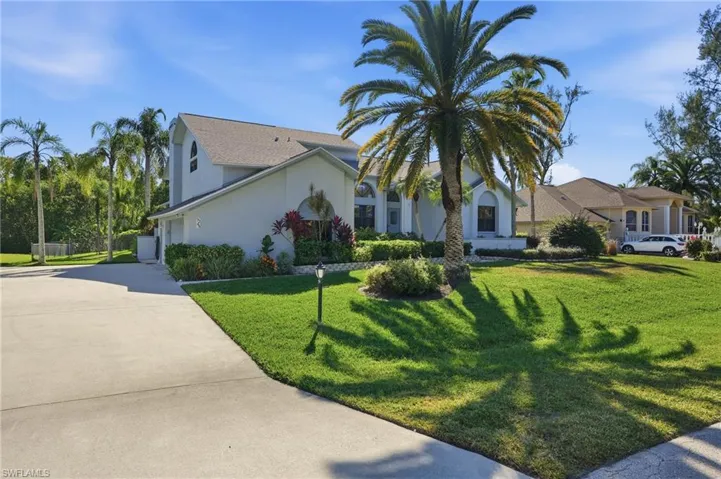 View of front of house with driveway, a front yard, stucco siding, and a garage
