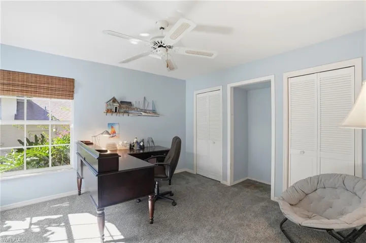 Carpeted office with baseboards and ceiling fan