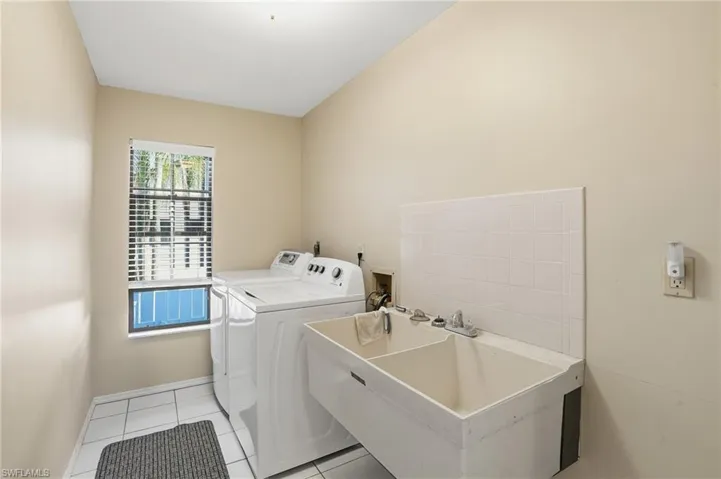 Laundry area featuring light tile patterned floors and washer and dryer