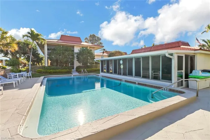 View of swimming pool with fence, a sunroom, a patio area, and a fenced in pool