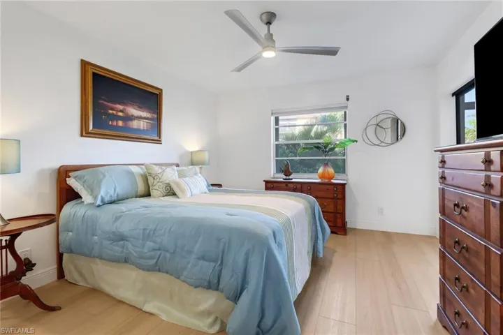 Bedroom with baseboards, light wood-type flooring, and a ceiling fan
