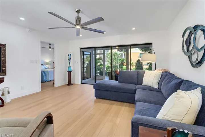 Living area featuring baseboards, light wood-style flooring, recessed lighting, and a ceiling fan