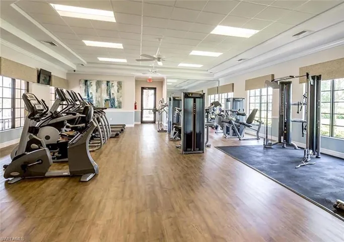 Workout area with a ceiling fan and a paneled ceiling
