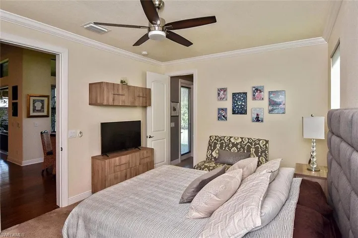 Bedroom featuring ornamental molding, wood finished floors, and ceiling fan
