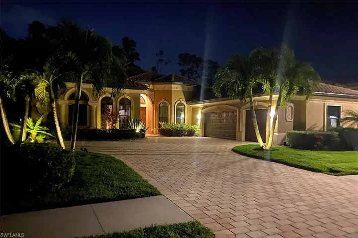 Mediterranean / spanish home featuring decorative driveway, an attached garage, stucco siding, and a yard
