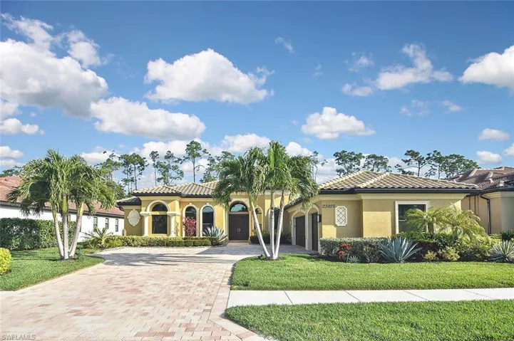 Mediterranean / spanish home with stucco siding, a tile roof, decorative driveway, and a front yard