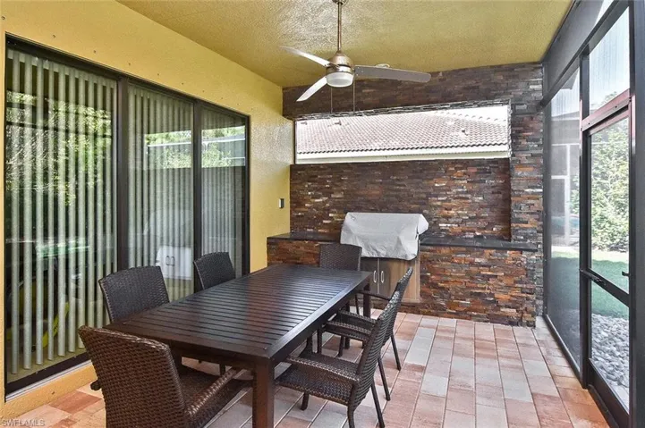 Sunroom / solarium featuring ceiling fan, outdoor dining area, and a patio