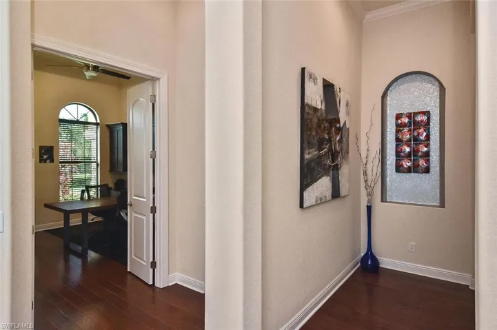 Corridor featuring dark wood-style flooring and baseboards