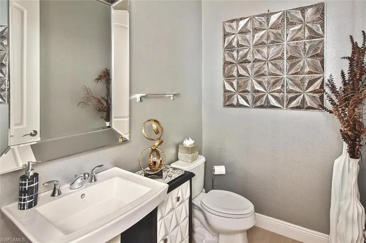 Half bath featuring baseboards and toilet