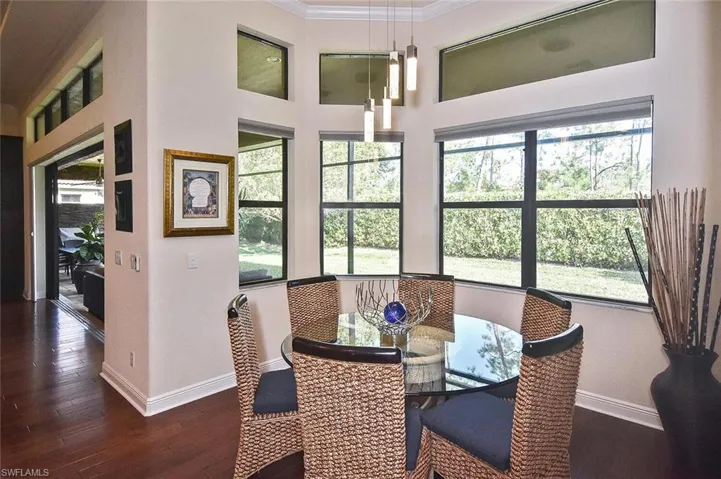 Dining room featuring crown molding, dark wood-style floors, and plenty of natural light