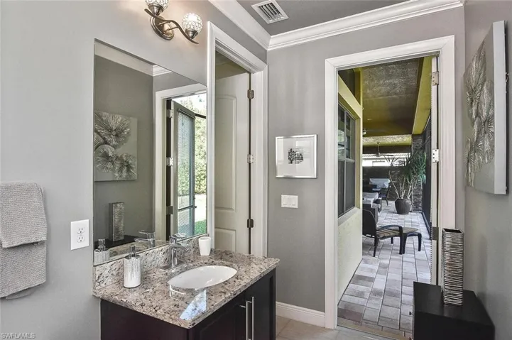 Half bath with ornamental molding, vanity, and plenty of natural light