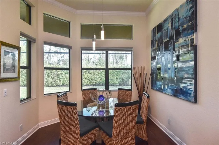 Dining space featuring ornamental molding and dark wood-type flooring
