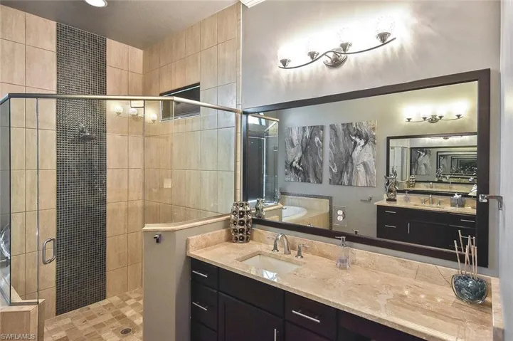 Full bath with a stall shower, vanity, and a garden tub