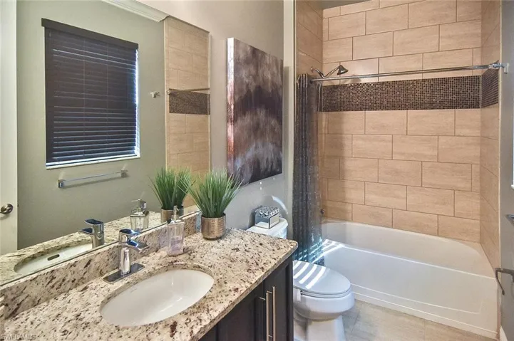 Full bathroom with shower / bath combo with shower curtain and vanity