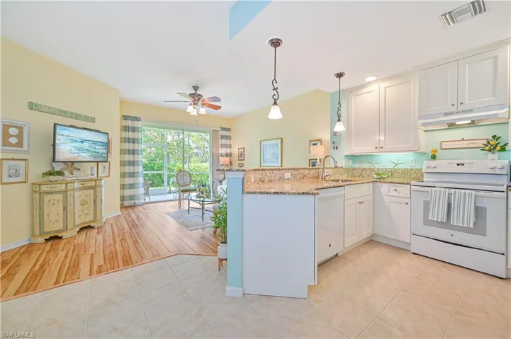 Kitchen featuring decorative light fixtures, light hardwood / wood-style floors, kitchen peninsula, ceiling fan, and white appliances