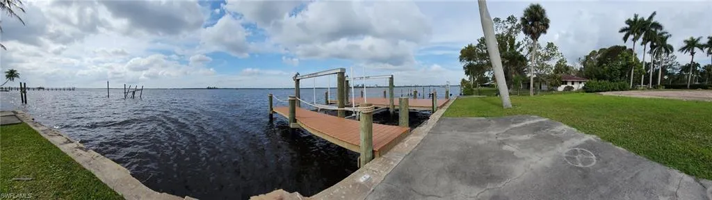 Dock area with a water view and a lawn