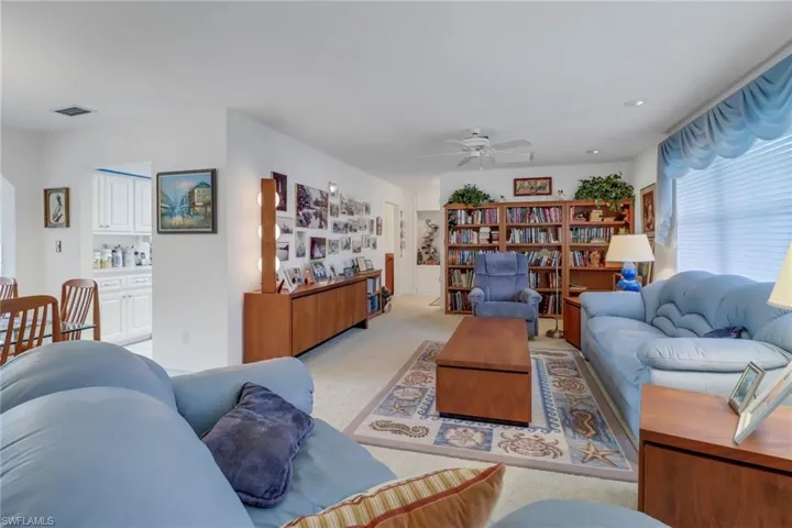 Carpeted living room with ceiling fan