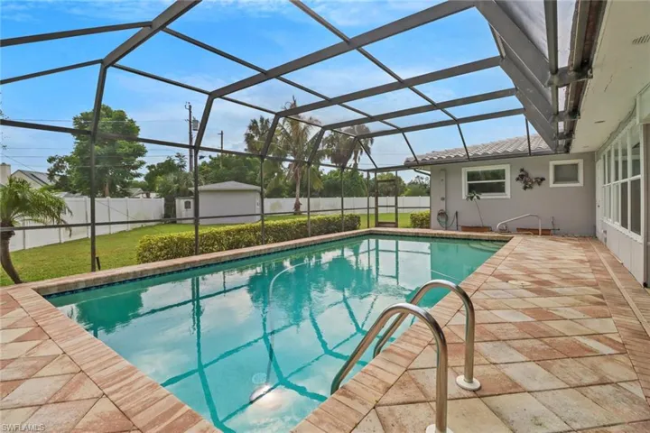 View of swimming pool with a patio area, a lanai, and a storage unit