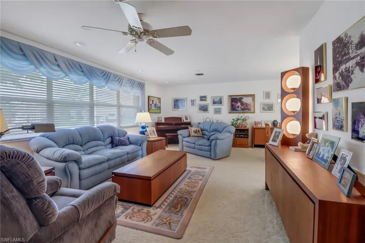 Living room featuring light colored carpet and ceiling fan