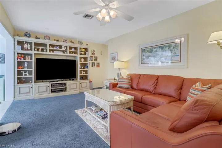 Carpeted living room with ceiling fan