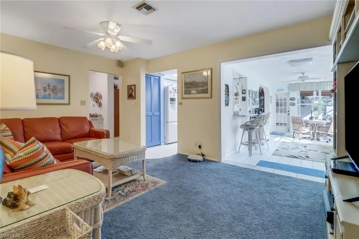 Carpeted living room featuring ceiling fan