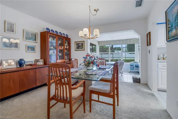 Dining area with a chandelier and light carpet