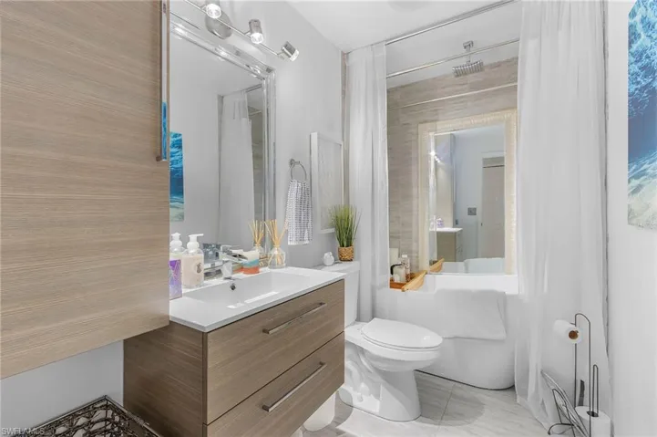 Bathroom with toilet, tub / shower combination, and vanity