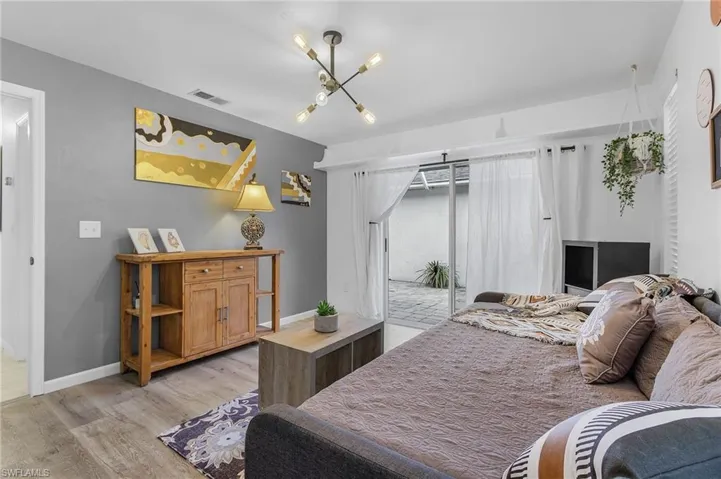 Bedroom with light hardwood / wood-style floors and an inviting chandelier