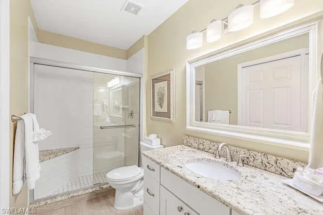 Full bathroom with vanity and a shower stall