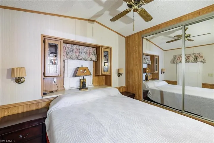 Bedroom with lofted ceiling, ornamental molding, a ceiling fan, a textured ceiling, and a closet