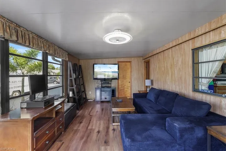 Living room featuring wood walls and dark wood finished floors