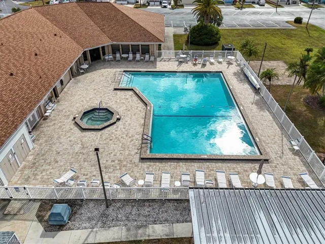 Community pool with a patio area, a fenced backyard, and a community hot tub